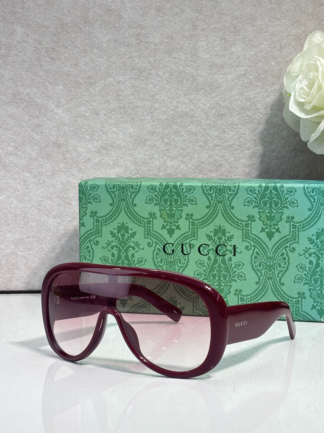 Gucci oversized sunglasses with burgundy frame and tinted lenses, with green logo case