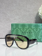 Gucci oversized sunglasses with dark navy frame and tinted lenses, curved temples