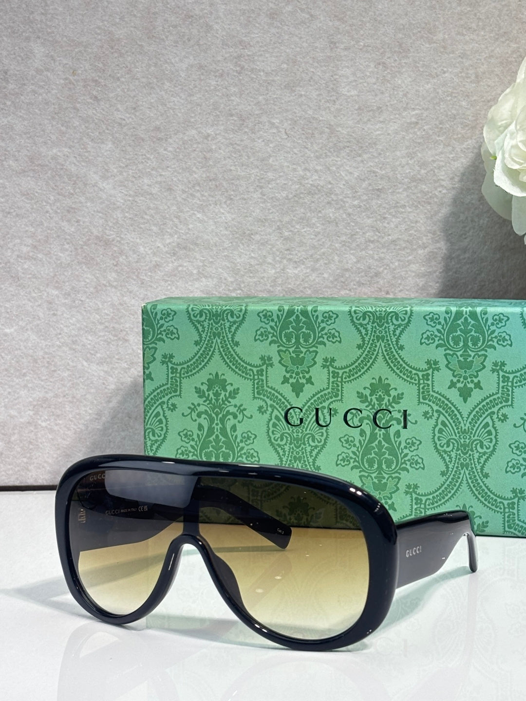 Gucci oversized sunglasses with navy frame and amber-tinted lenses, tortoiseshell arms