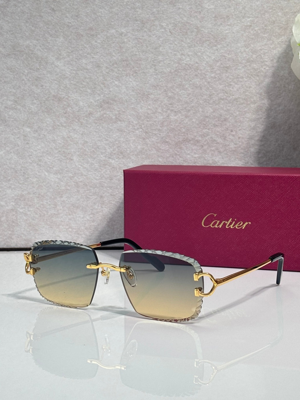 Cartier glasses with gold frame, amber lenses, and dark side arms with decorative trim