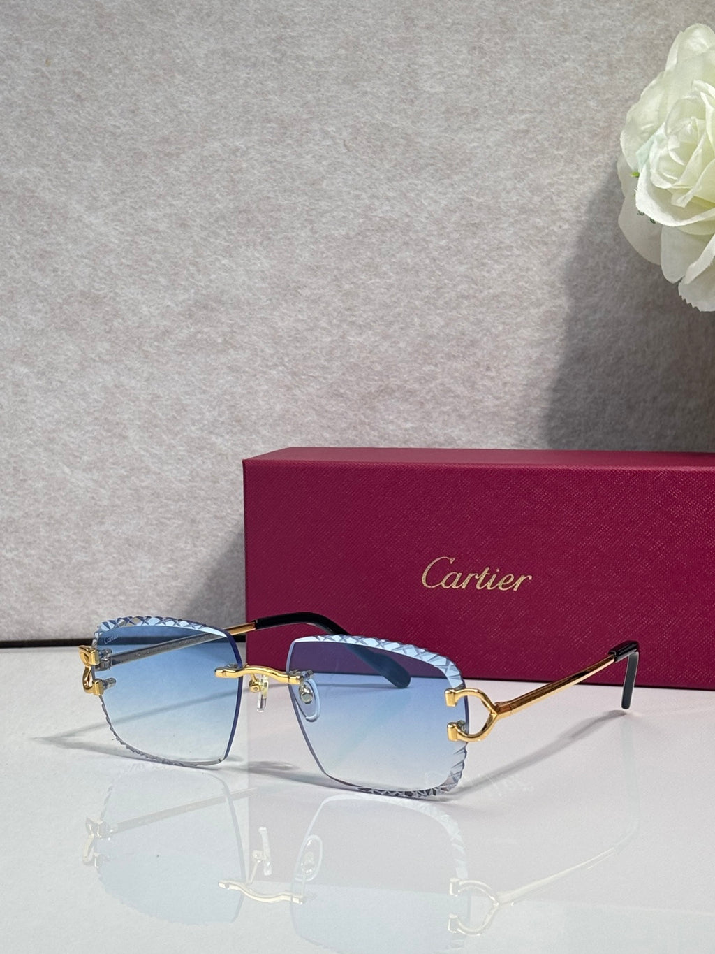Cartier glasses with gold frame, blue tinted lenses, and dark side arms