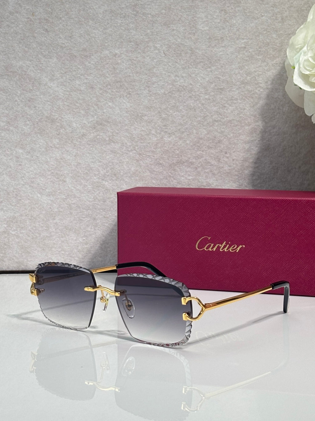 Cartier glasses with gold frame, dark lenses, and navy side arms