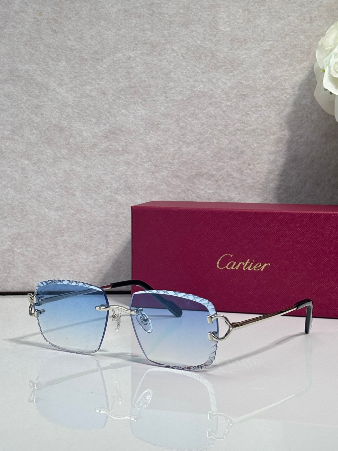 Cartier glasses with gold frame, light blue tinted lenses, and dark side arms