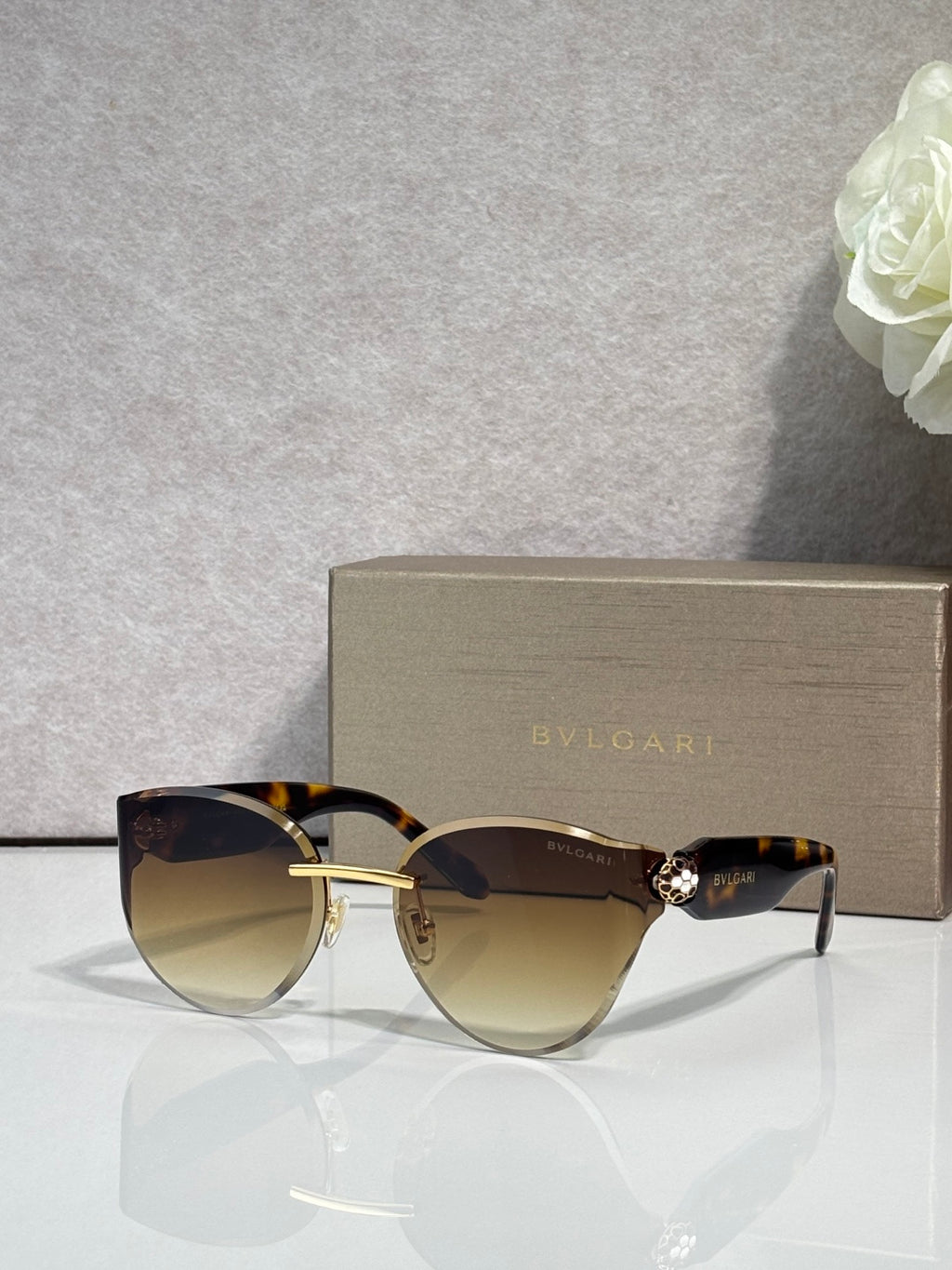 Bvlgari sunglasses with gold-tone frame and dark brown gradient lenses, gold accents