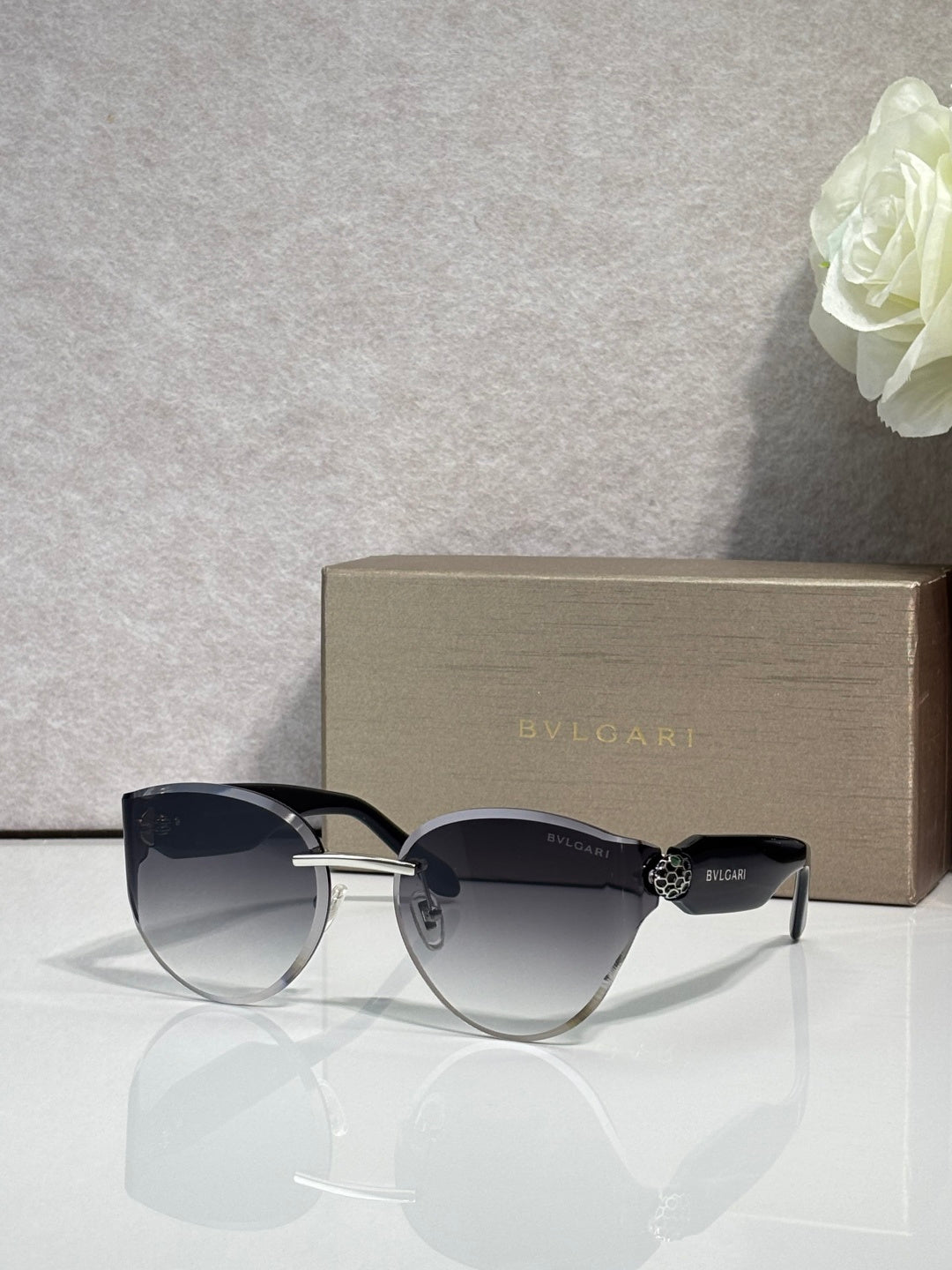 Bvlgari sunglasses with black frame and dark gradient lenses, gold hinge details