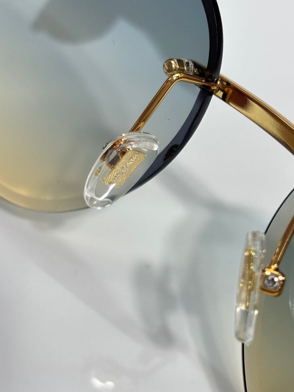 Bvlgari sunglasses close-up of gold-tone temple hardware and blue-tinted lens edge