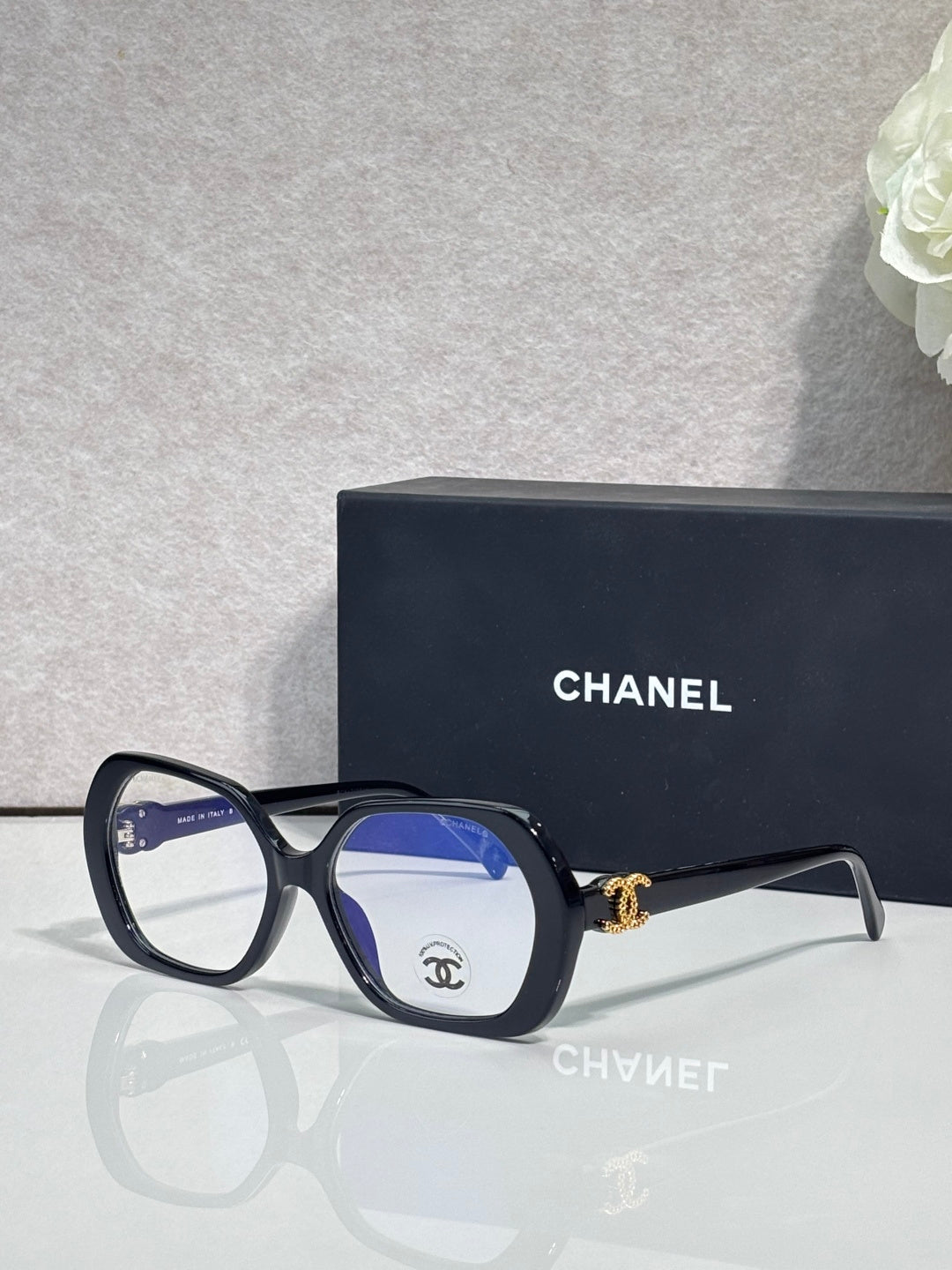 Eyeglasses with dark blue frame, blue lenses, CHANEL logo on temple