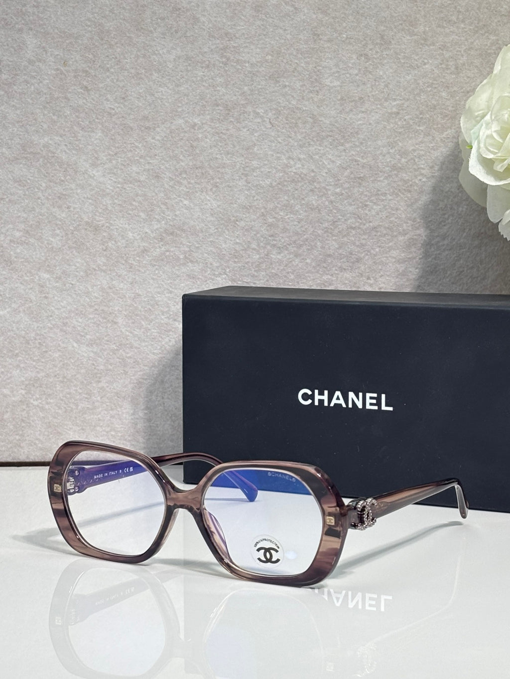 Eyeglasses with brown frame, blue lenses, CHANEL logo on temple