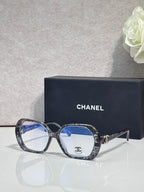 Eyeglasses with dark purple frame, blue lenses, CHANEL logo on temple
