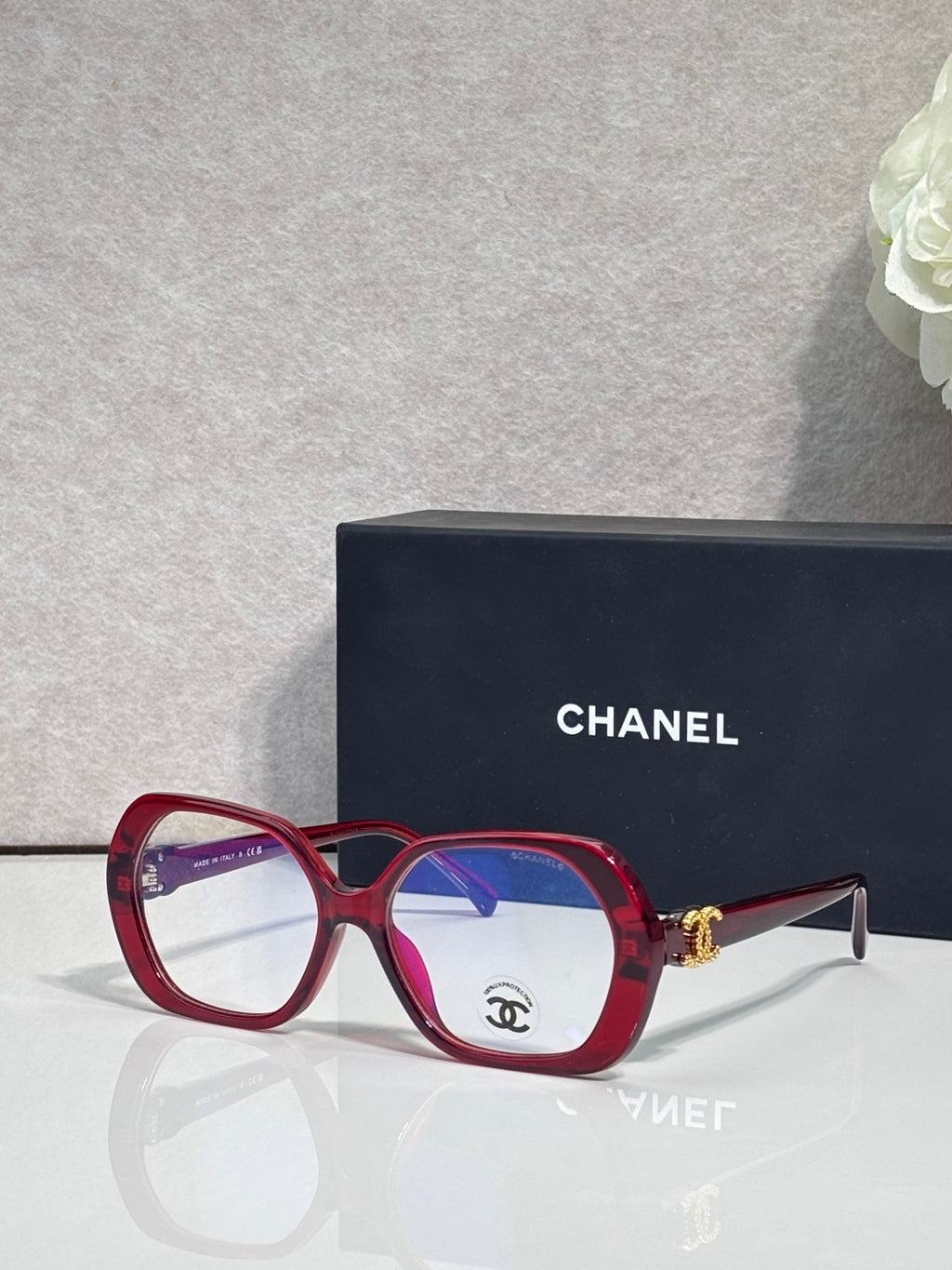 Eyeglasses with red frame, blue lenses, CHANEL logo on temple