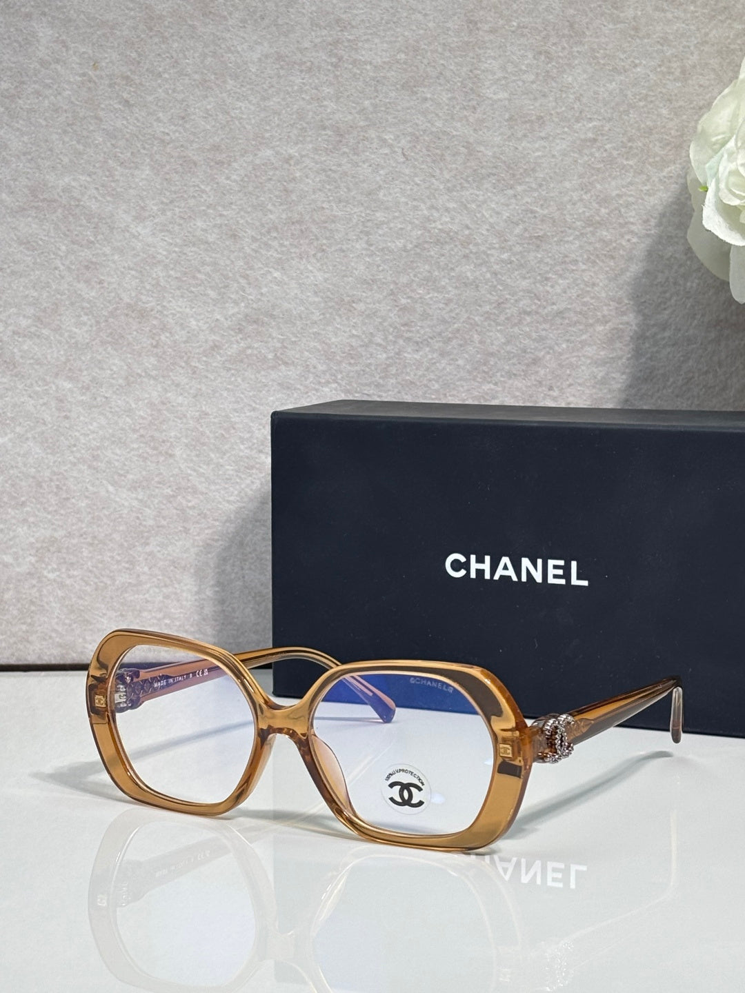 Eyeglasses with gold frame, blue lenses, CHANEL logo on temple