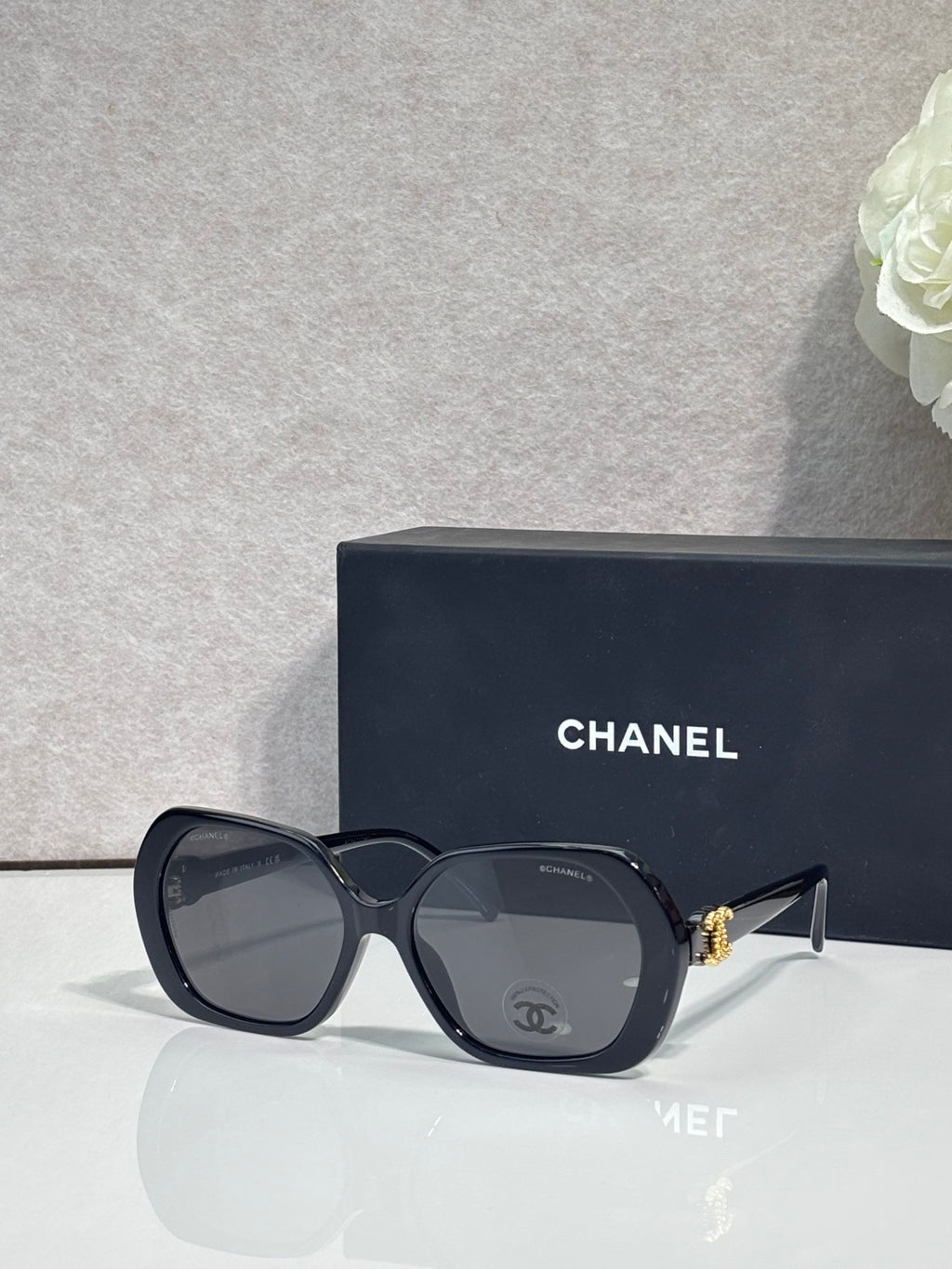 Chanel navy square sunglasses with logo on the temple and tinted lenses.