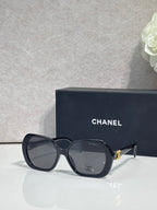 Chanel navy square sunglasses with logo on the temple and tinted lenses.