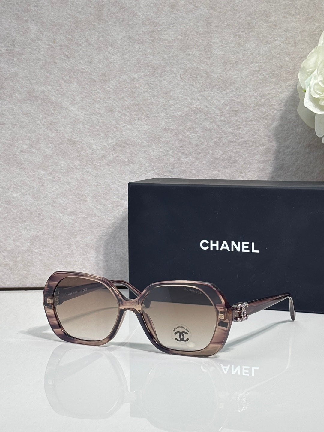 Chanel burgundy square sunglasses with gold-toned logo on the temple and tinted lenses.