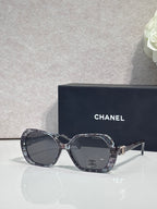 Chanel black square sunglasses with logo on the temple and tinted lenses.