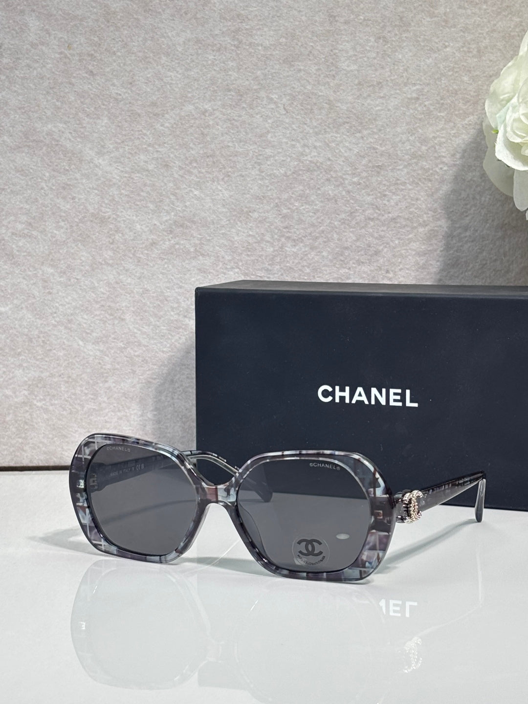 Chanel black square sunglasses with logo on the temple and tinted lenses.