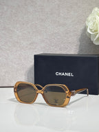 Chanel brown square sunglasses with gold-toned temple accents and tinted lenses.