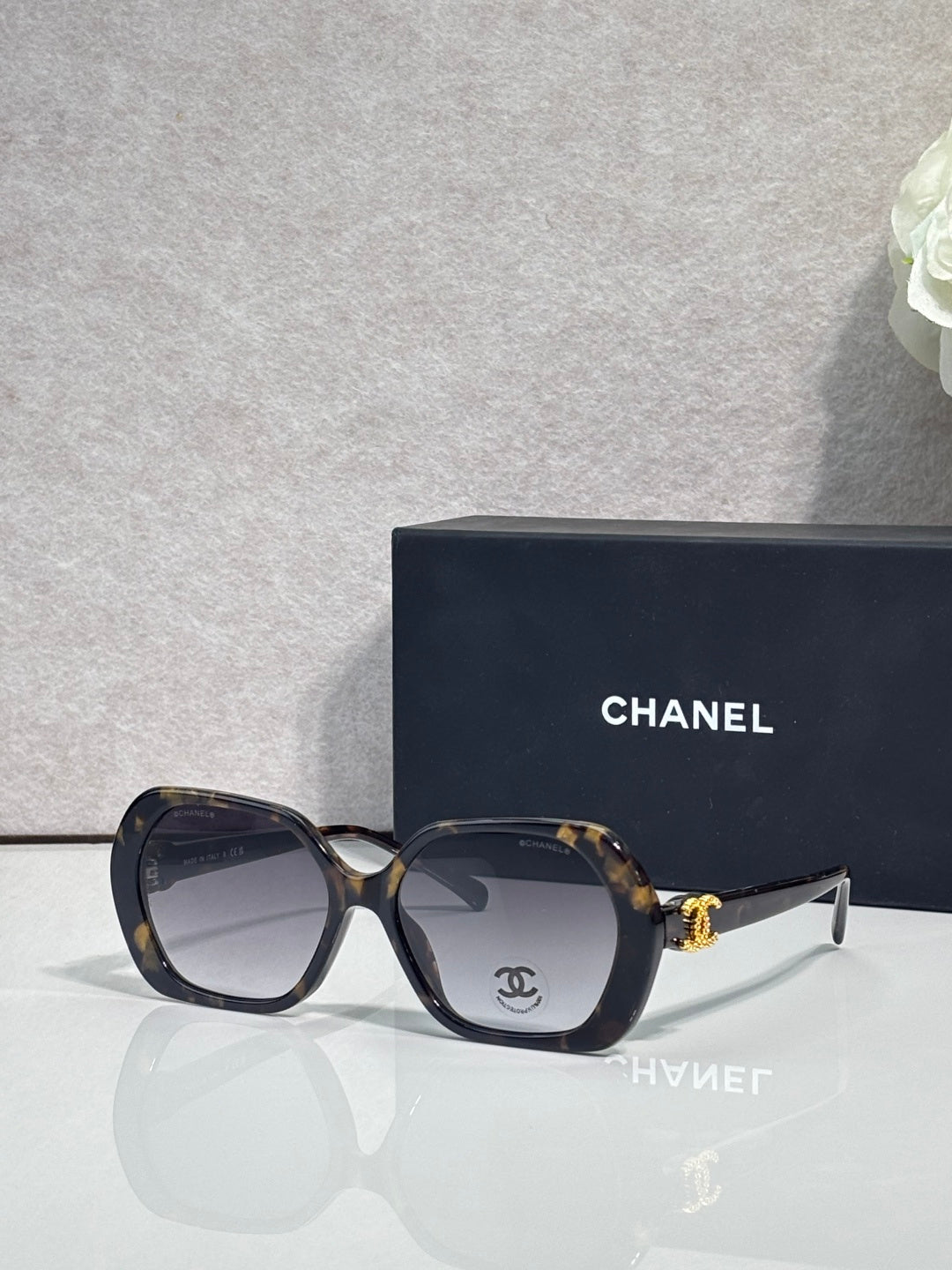 Chanel dark blue square sunglasses with logo on the temple and tinted lenses.