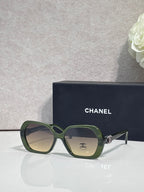 Chanel green square sunglasses with logo on the temple and tinted lenses.