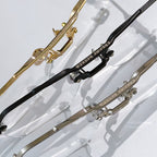 Gold and black metal eyeglass frame temples with sculpted decorative hardware