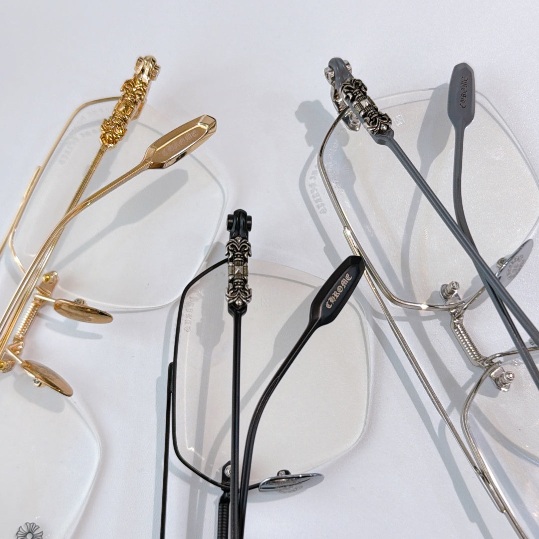 Gold and black eyeglass frames with clear lenses and decorative temple hardware