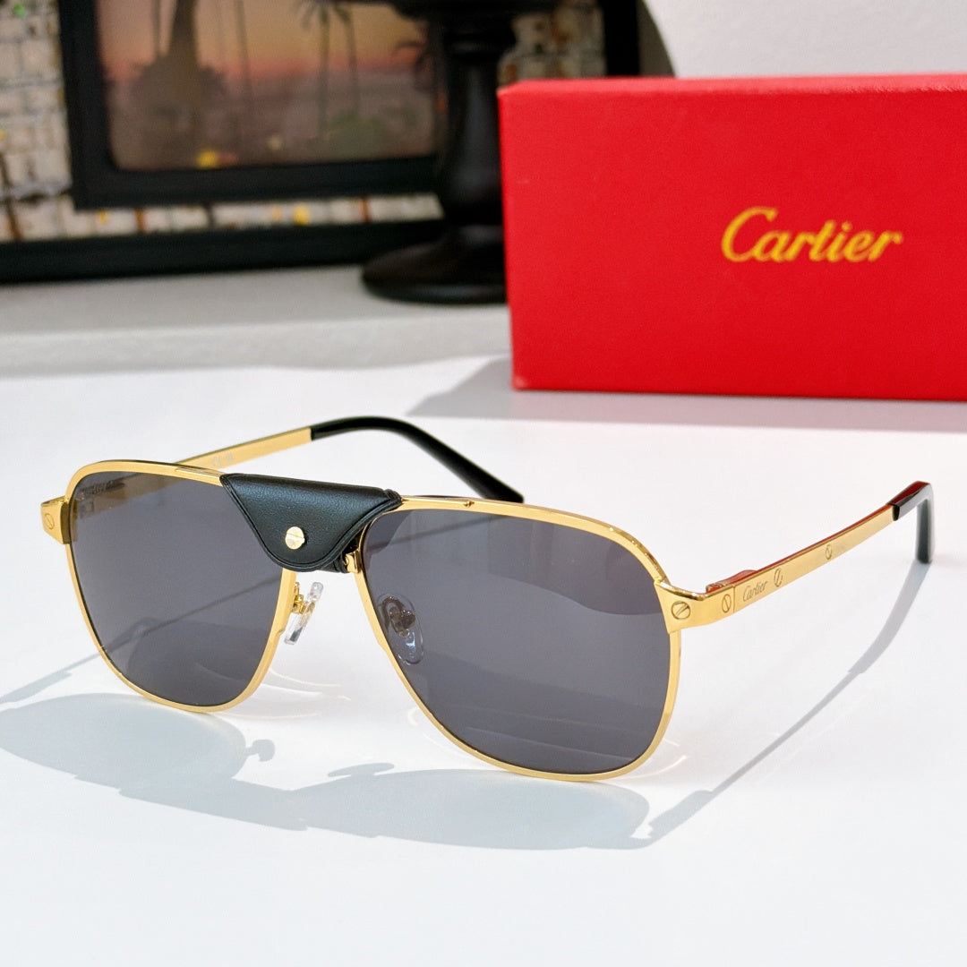 Sunglasses with gold frames, dark tinted lenses, and black leather bridge detail