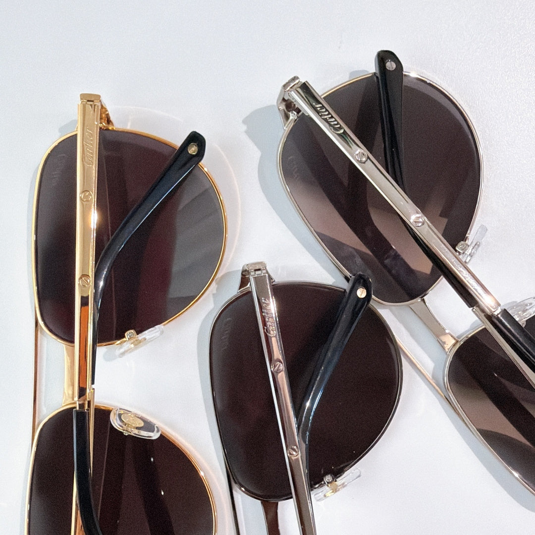 Stacked sunglasses with metal frames and dark lenses, close-up