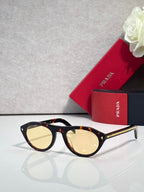 Prada sunglasses with tortoiseshell frames and light yellow lenses
