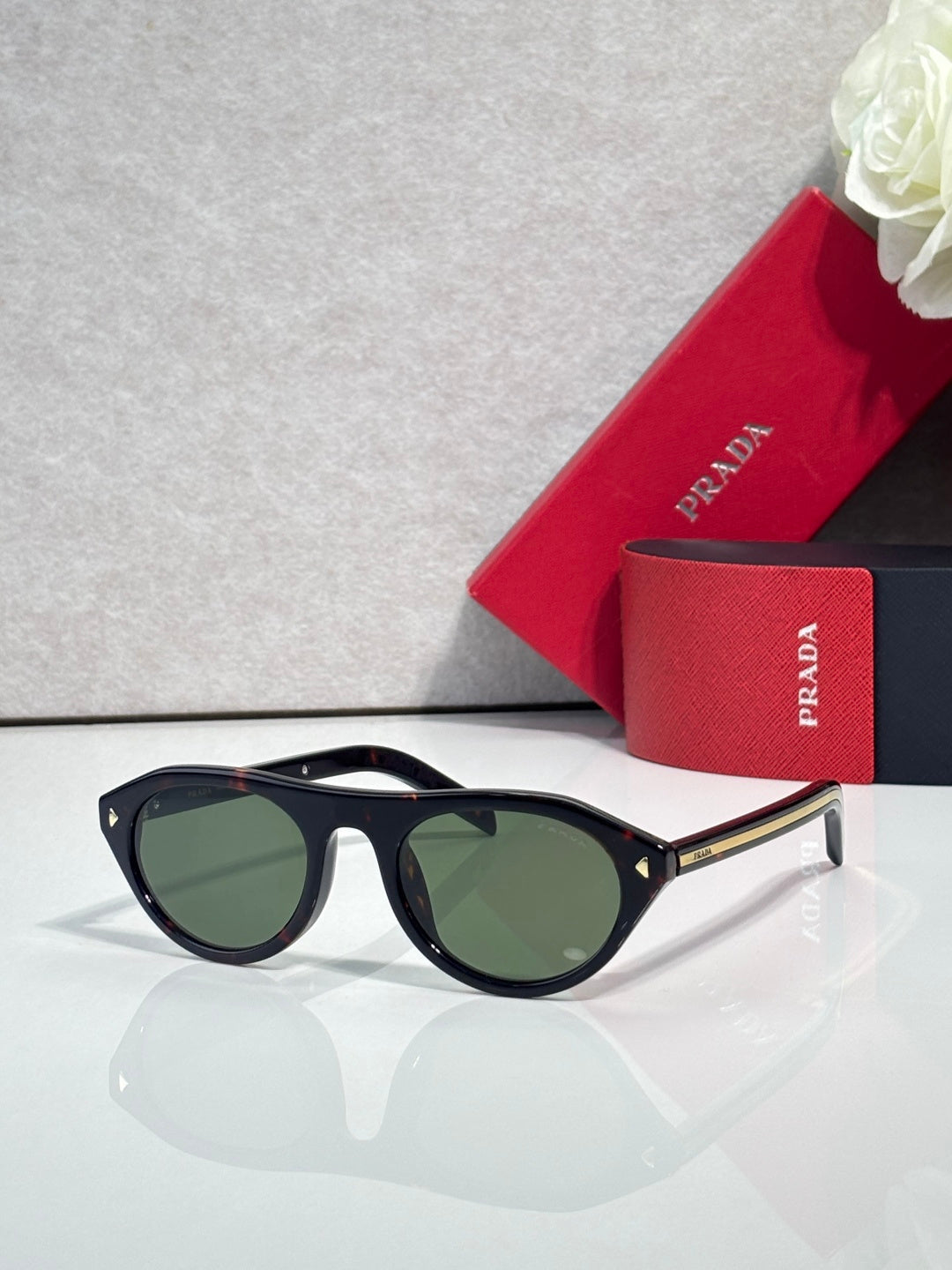 Prada sunglasses with black frames and dark green lenses