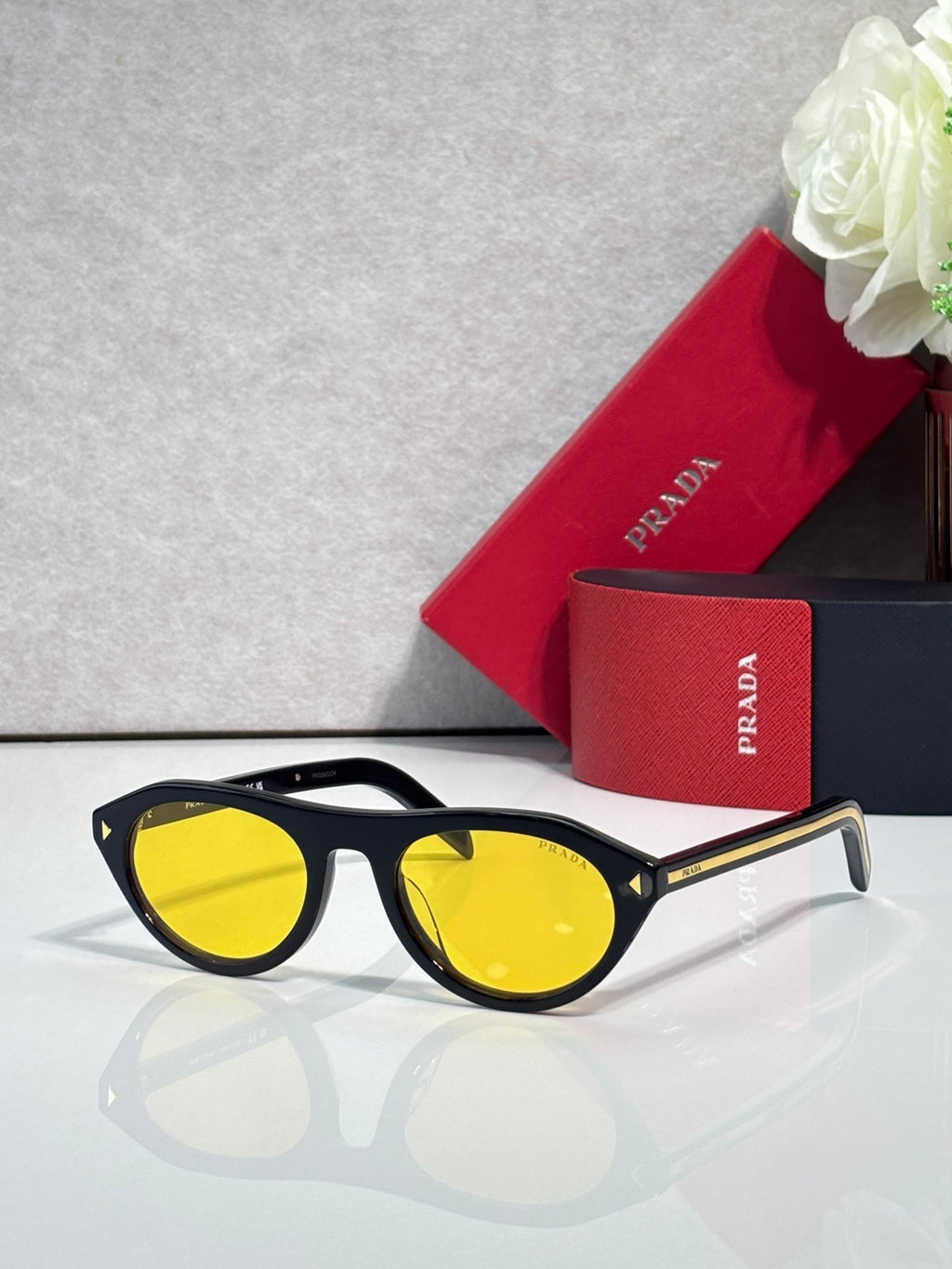 Prada sunglasses with black frames and yellow tinted lenses