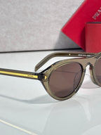 Round Prada sunglasses with gold frame and brown lenses