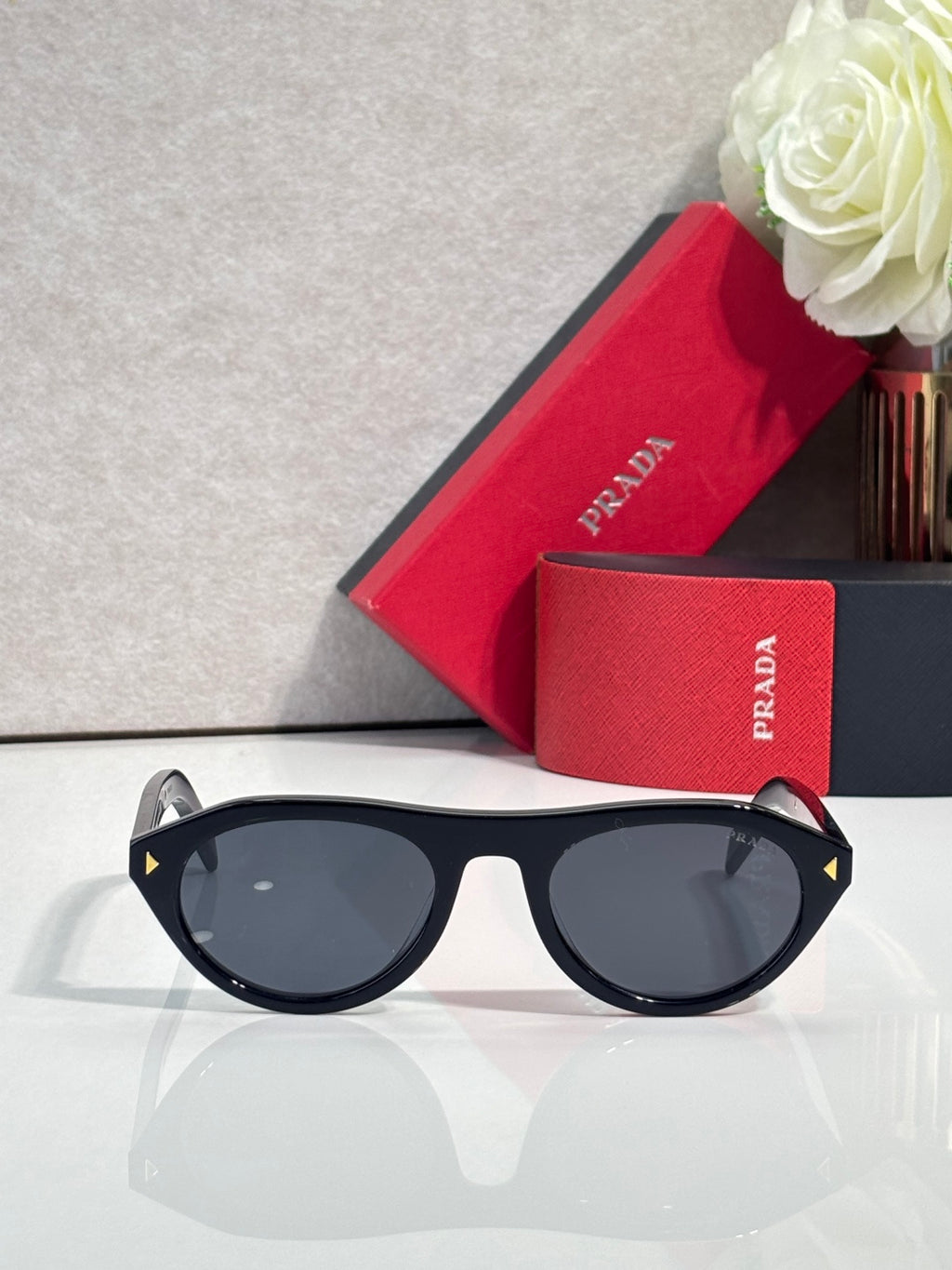 Black Prada sunglasses with dark round lenses and slim temples