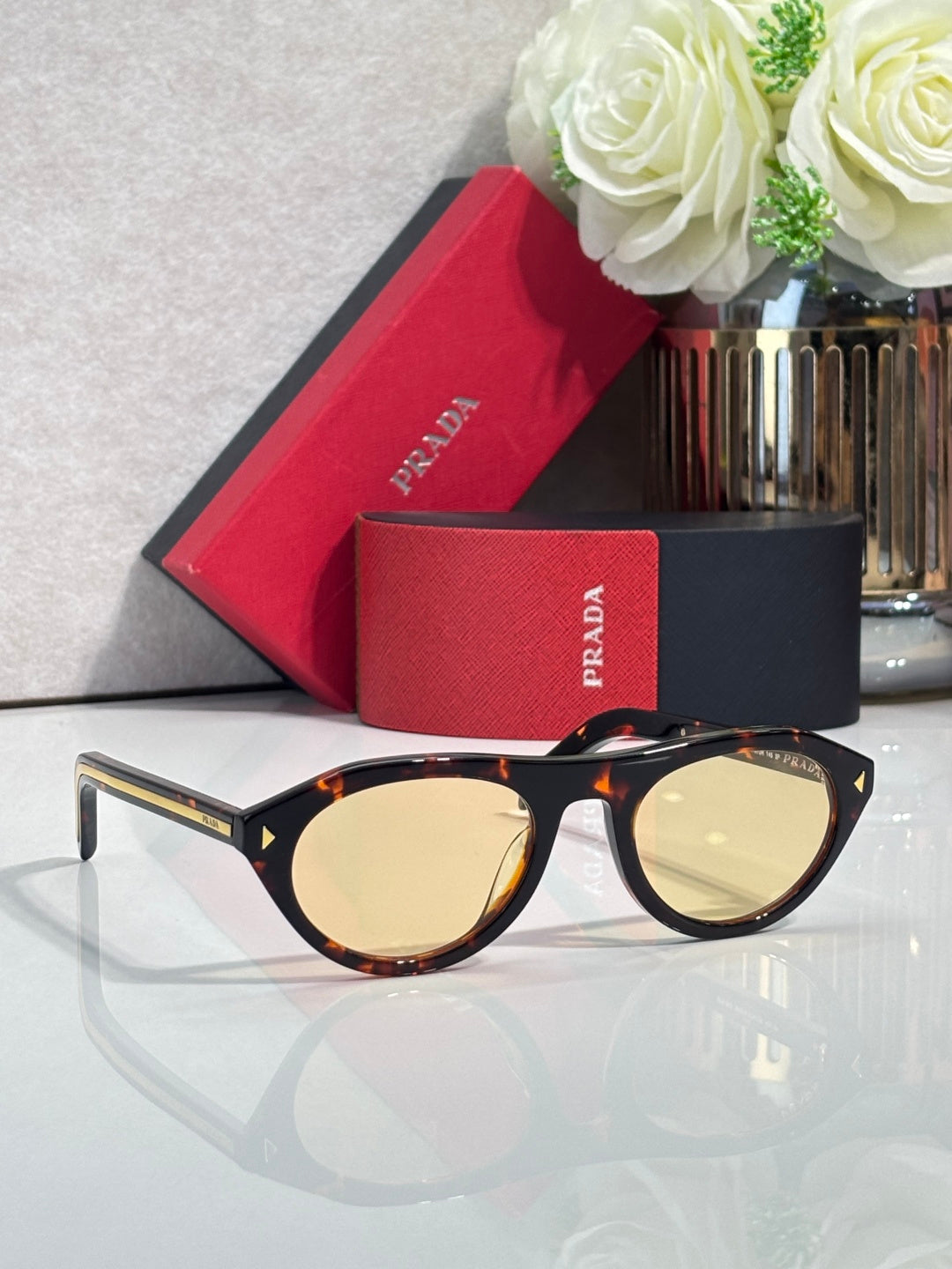 Tortoiseshell Prada sunglasses with yellow-tinted round lenses and gold accents