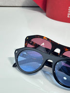 Dark sunglasses with blue-tinted lenses and tortoiseshell temples
