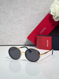 Prada round sunglasses with black lenses and gold-tone metal frame, black temples