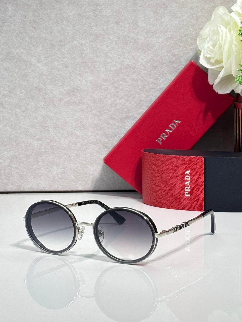 Prada round eyeglasses with dark lenses, black frame, silver metal temples