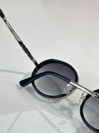 Prada round eyeglasses side close-up, dark lens and black temple tip