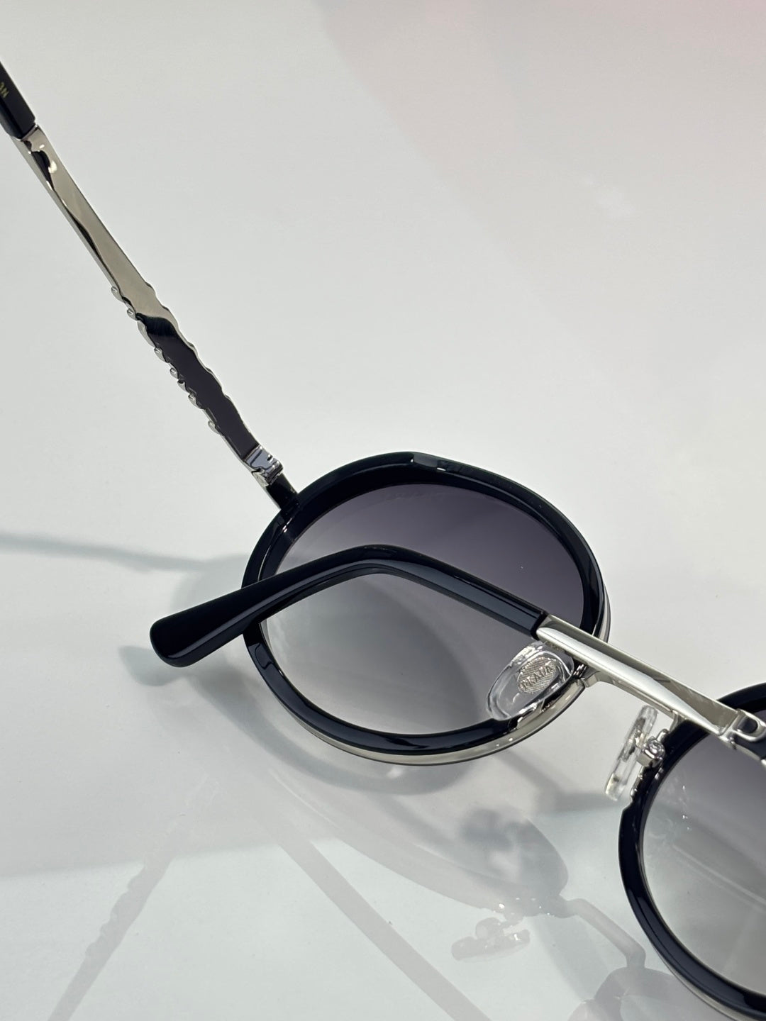 Prada round eyeglasses side close-up, dark lens and black temple tip