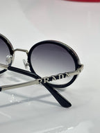 Prada round eyeglasses close-up, PRADA on frame, black temple