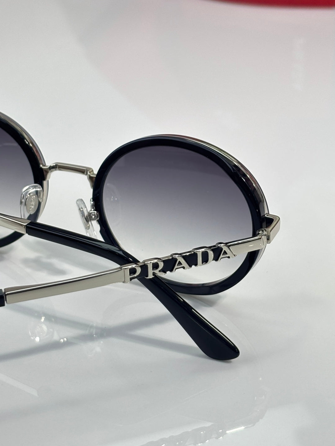 Prada round eyeglasses close-up, PRADA on frame, black temple