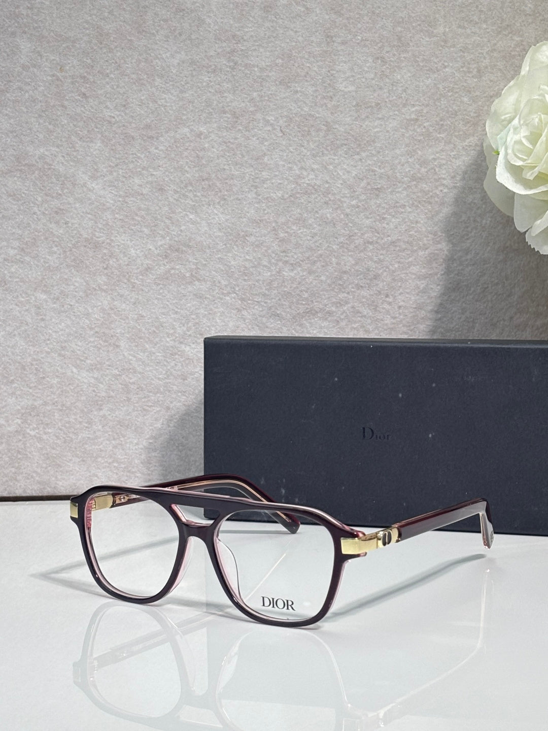 Rectangular eyeglasses with dark red frame, clear lenses, and Dior logo on bridge