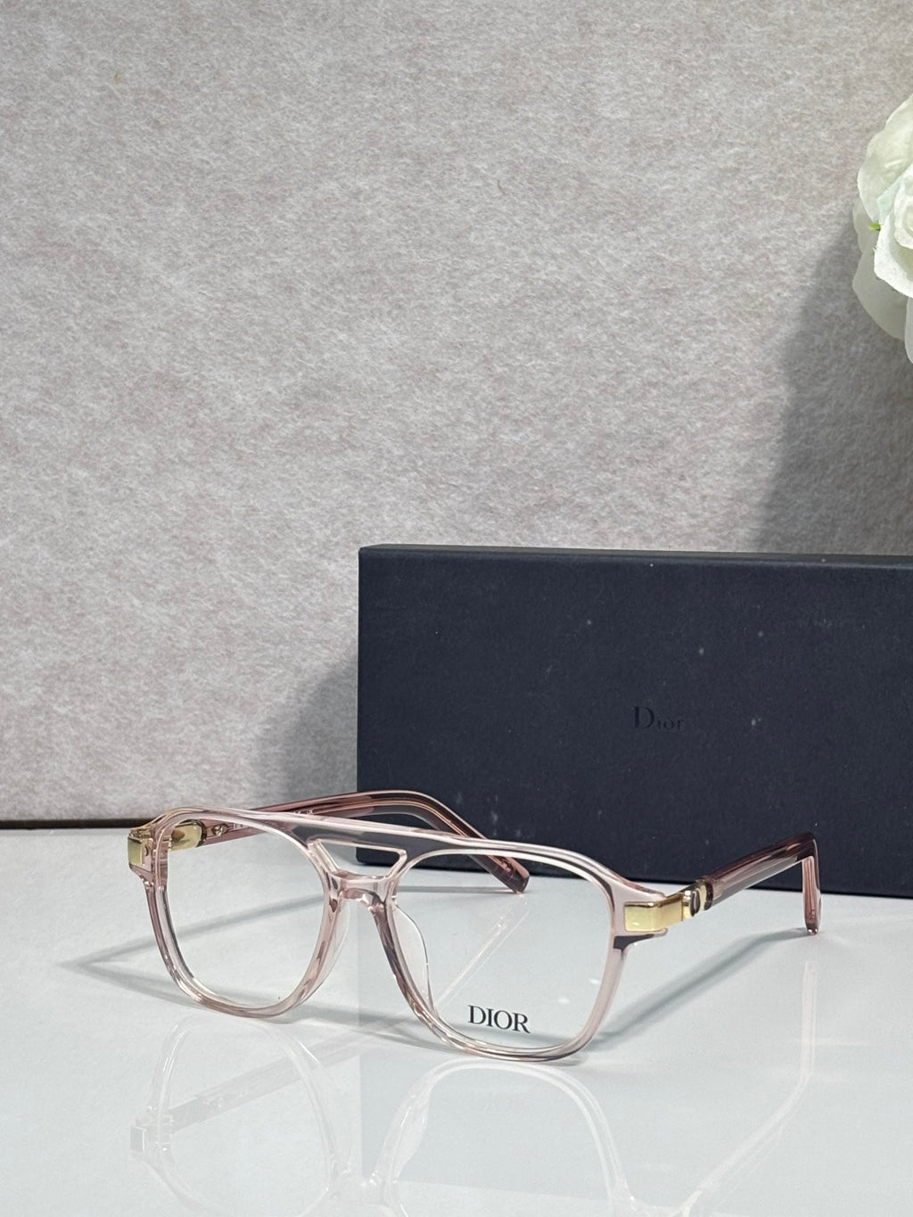 Rectangular eyeglasses with light pink frame, clear lenses, and Dior logo on bridge