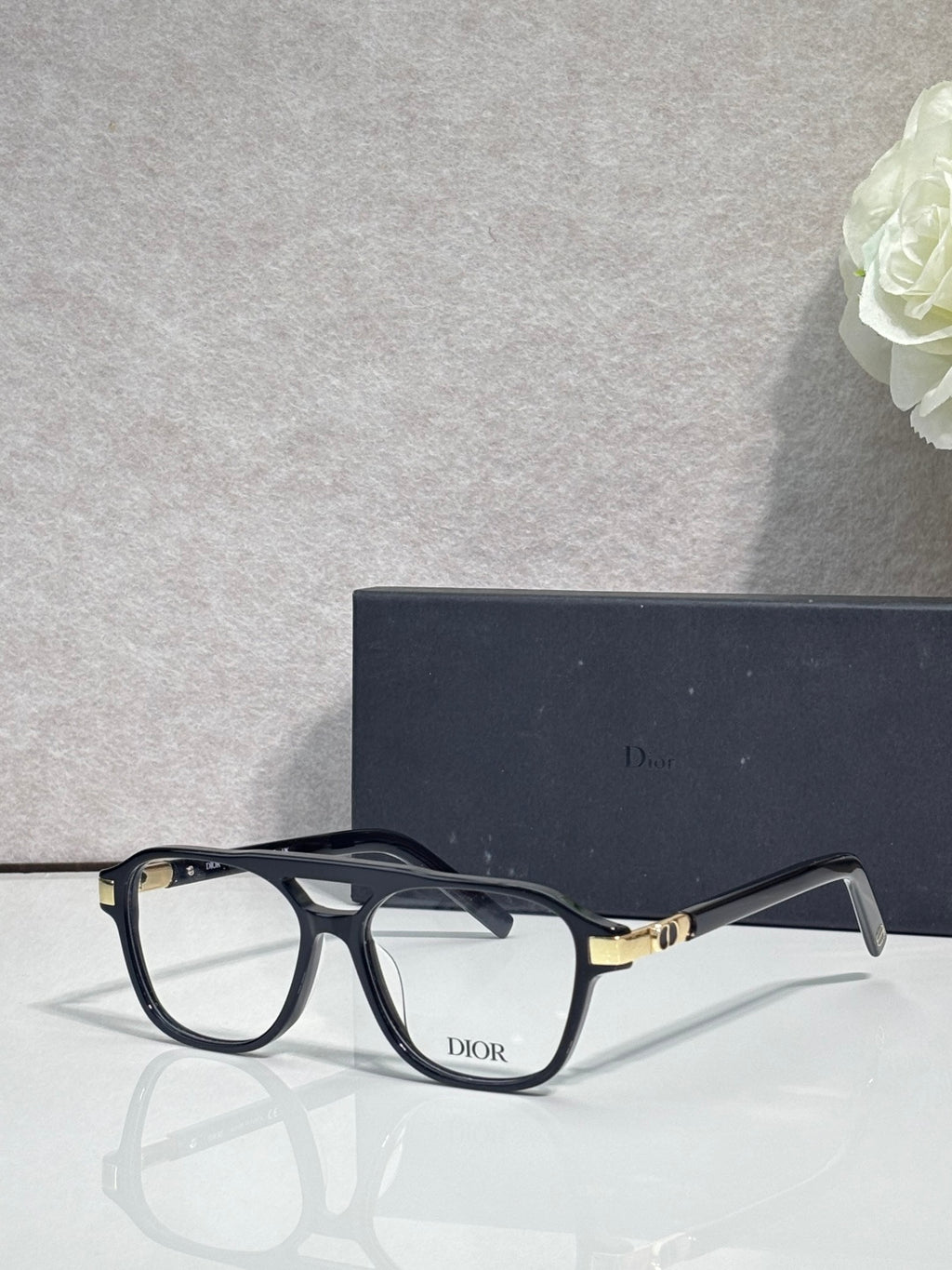 Rectangular eyeglasses with black frame and clear lenses, gold-tone hinge detail
