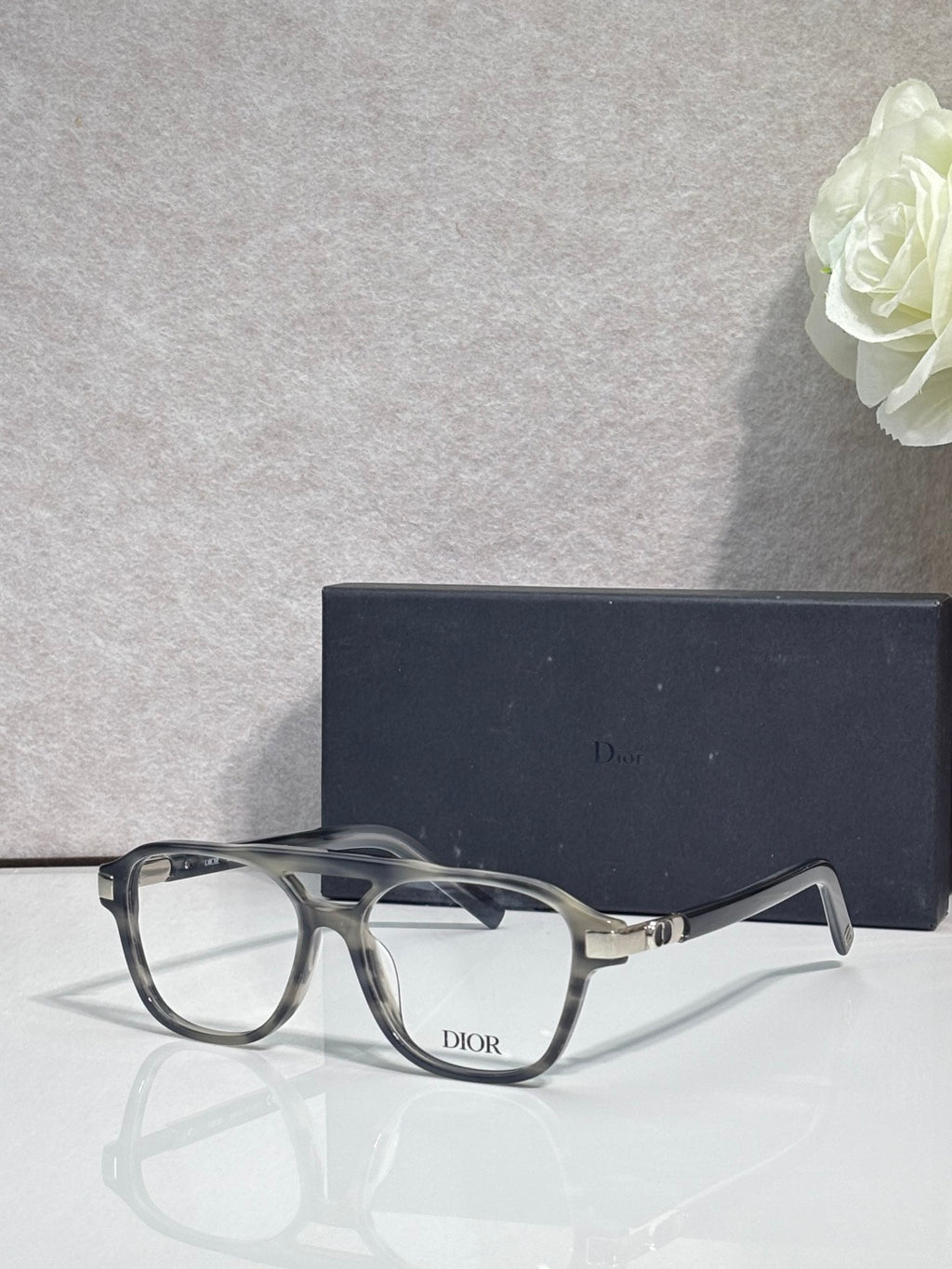Rectangular eyeglasses with dark frame, clear lenses, and Dior logo on temple