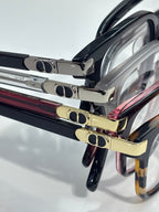 Stacked Dior eyeglasses close-up showing black frames and gold-tone metal details