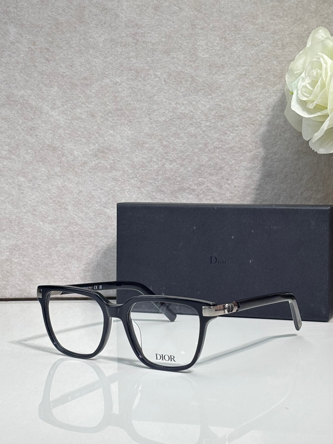 Dior eyeglasses with dark frames, clear lenses, and visible “Dior” logo at the bridge.