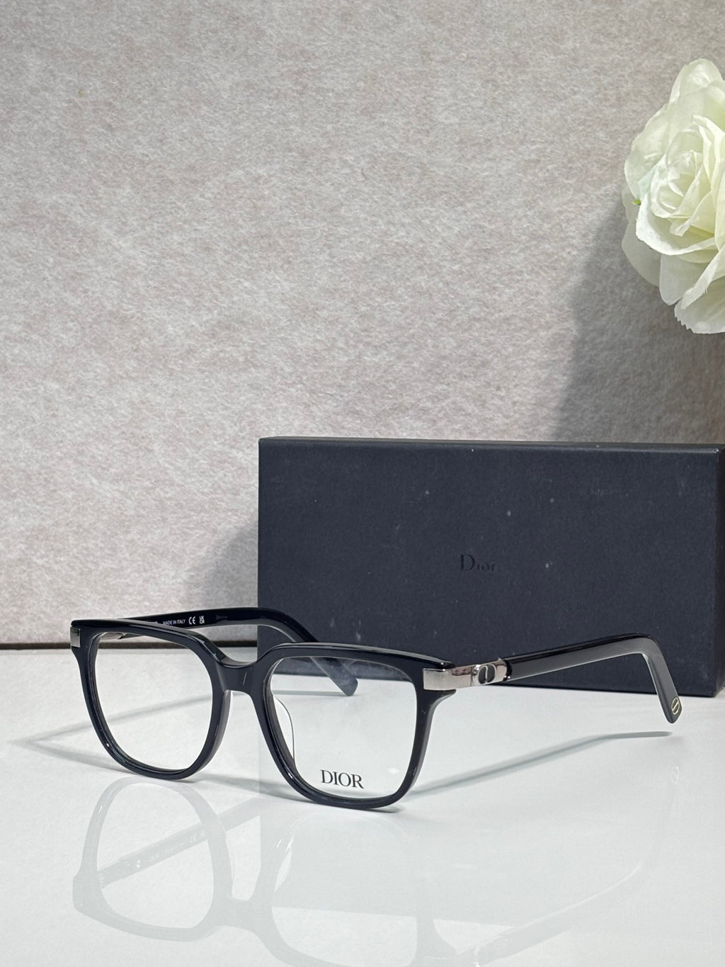 Dior optical glasses with dark navy/black rectangular frames and gold front accents.