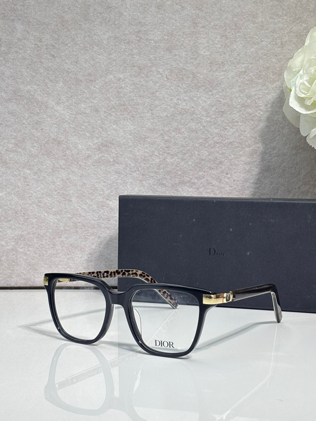 Dior optical glasses with dark frames and leopard-pattern detail on the upper temple.