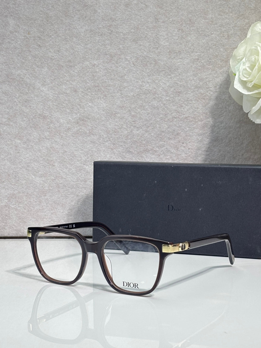 Dior eyeglasses with dark frames, clear lenses, and gold-toned bridge hardware.