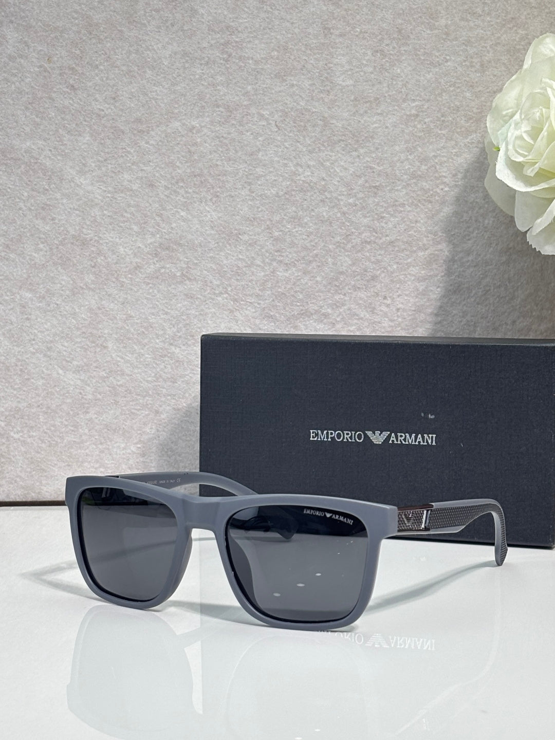 Designer glasses with light gray frames and dark tinted square lenses